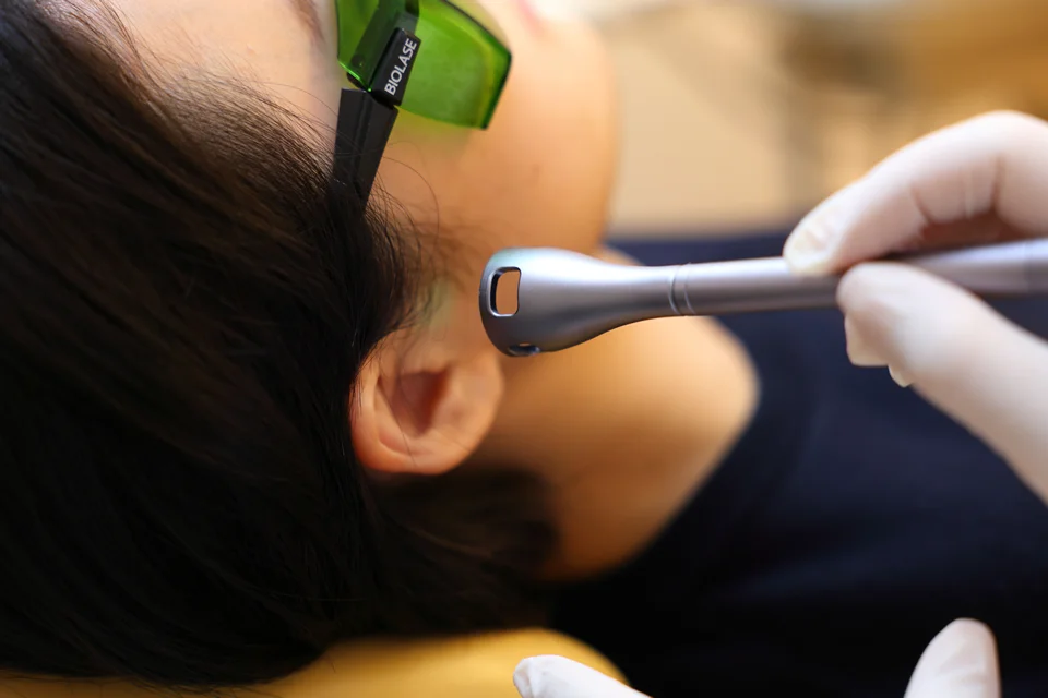歯科医院で行われる顎関節症の痛みを和らげるための最新レーザー治療の様子